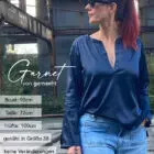 Frau in blauem Satin-Top und Jeans.