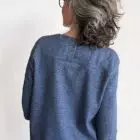 Person mit grauem Haar, blauem Shirt